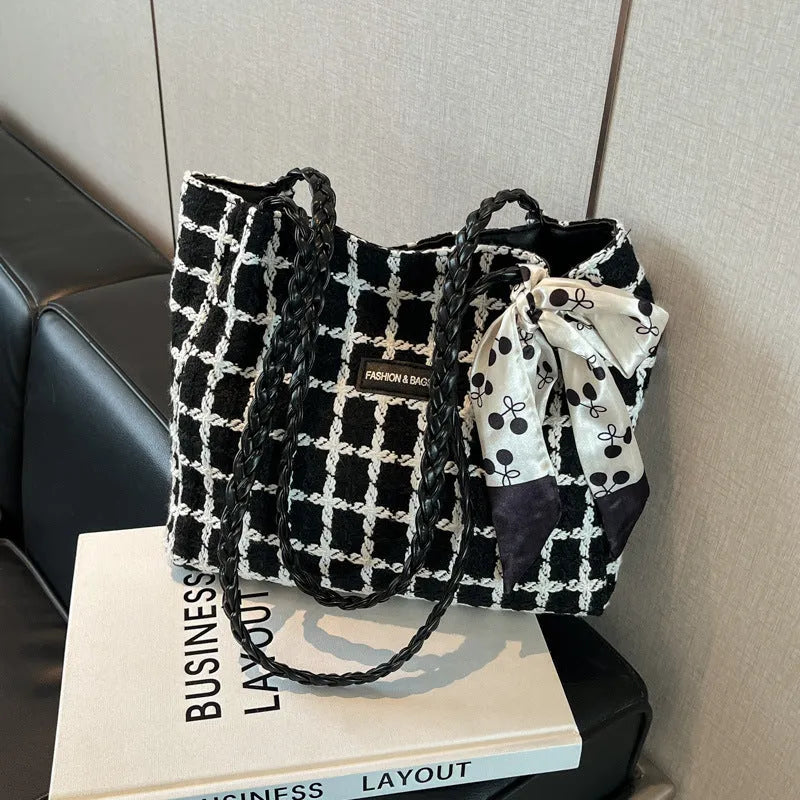 Black woven wool shoulder bag showing internal organisation with phone pocket, document section and zipper compartment
