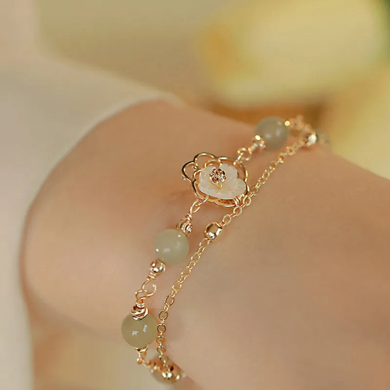 Yellow gold shell flower butterfly bracelet for women with geometric shape and bells of Ireland design