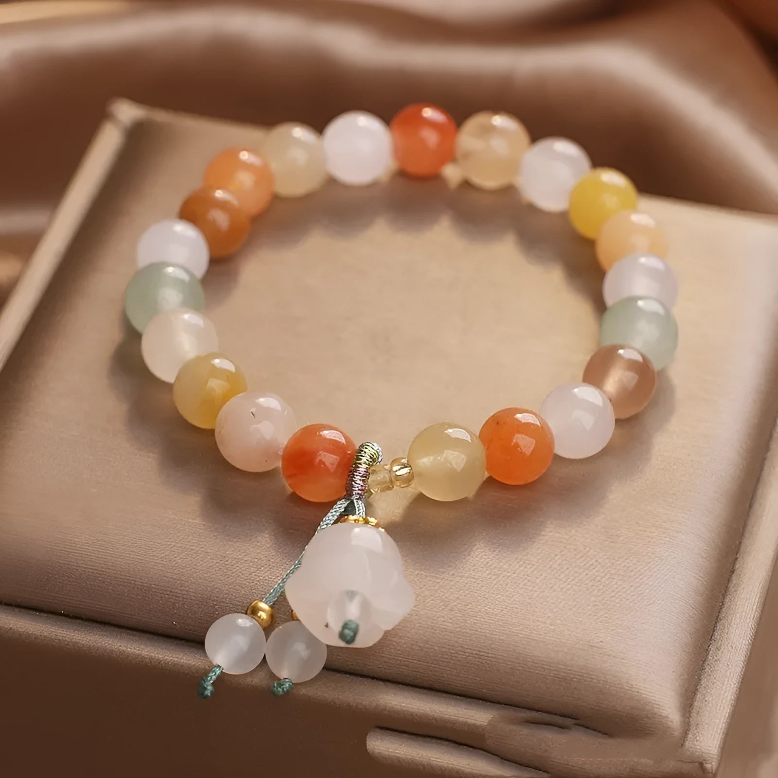 Natural Jinsi Jade round bead beaded bracelet with lily pendant on neutral background