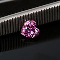 Loose lemon yellow heart-shaped moissanite stone on a plain background showing its size and cut.