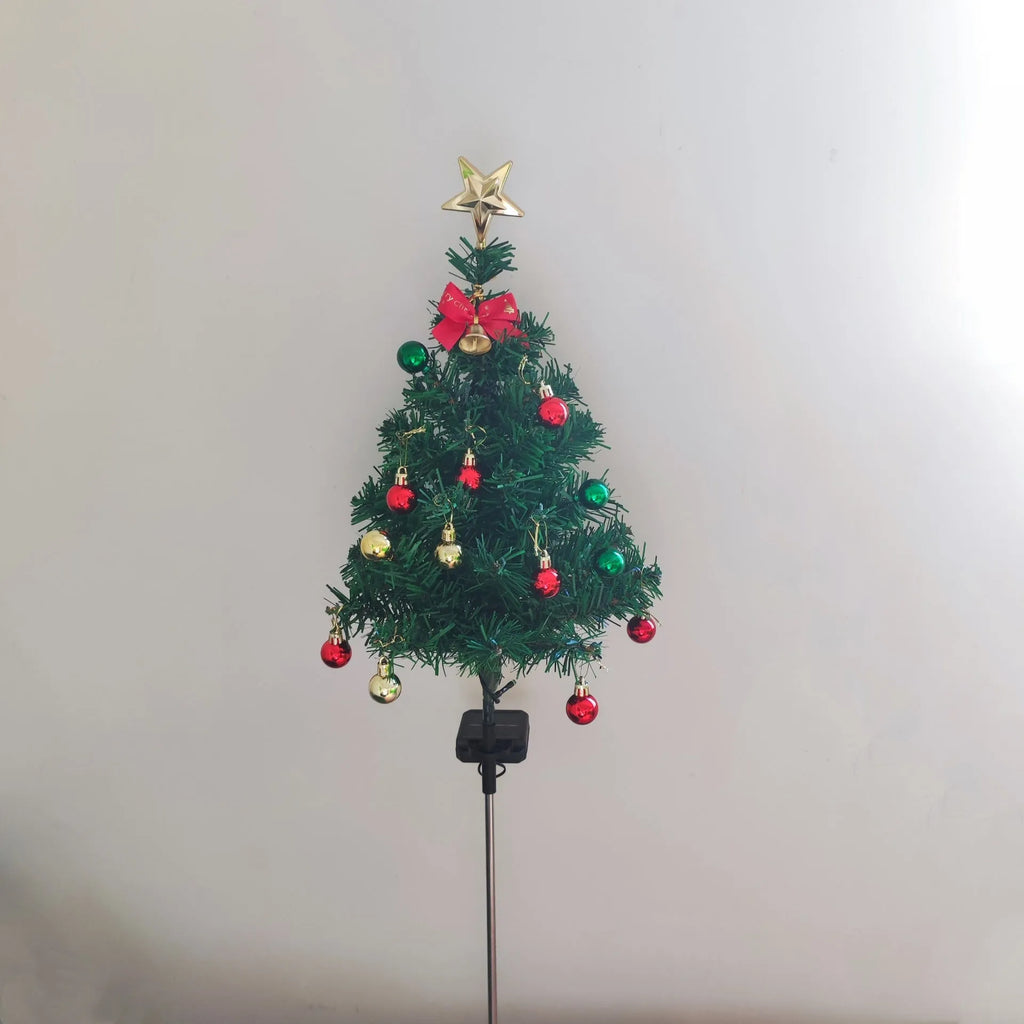 Solar Christmas tree lamp with ABS body placed on grass in a garden setting