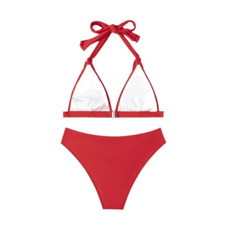 Red women's lace-up halterneck bikini set with matching shorts on a plain background.