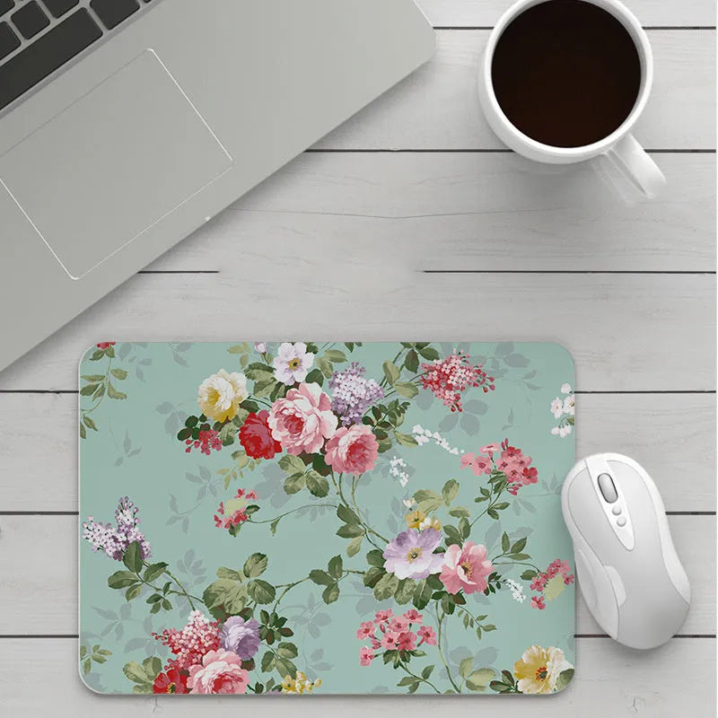 Custom cartoon design on a small black thickened mouse pad with stitching, shown on a desk.