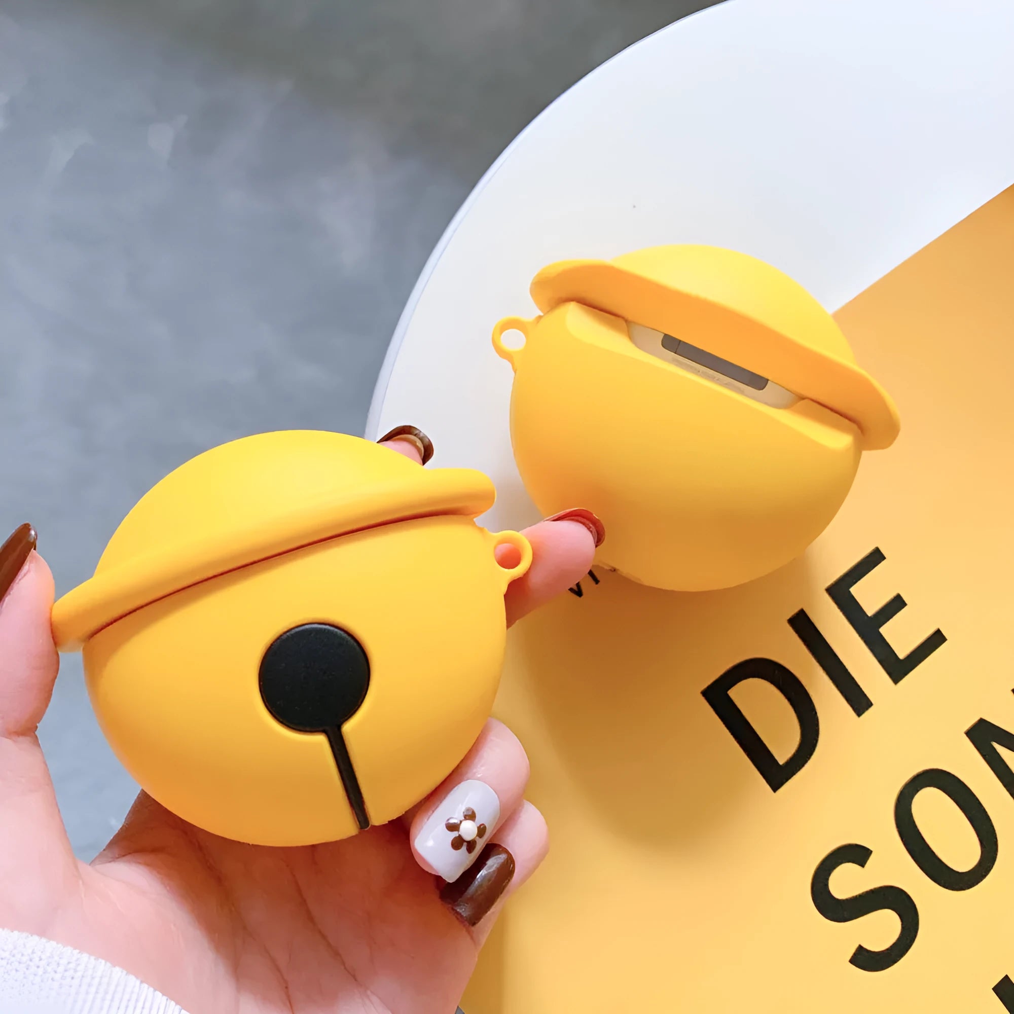 Yellow silicone case with bell charm for AirPods 1 and 2 generation wireless earphones