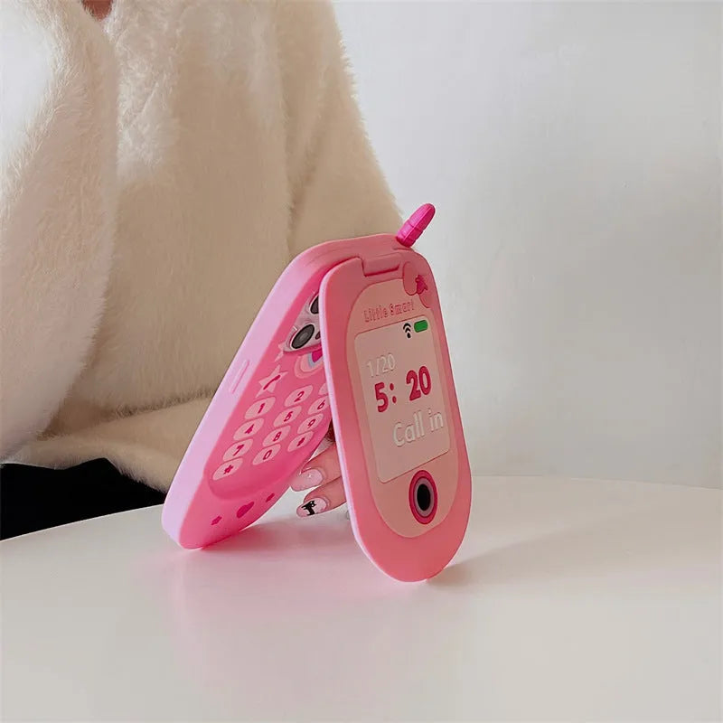 Pink silicone flip phone case open to show built-in mirror and iPhone compatibility.