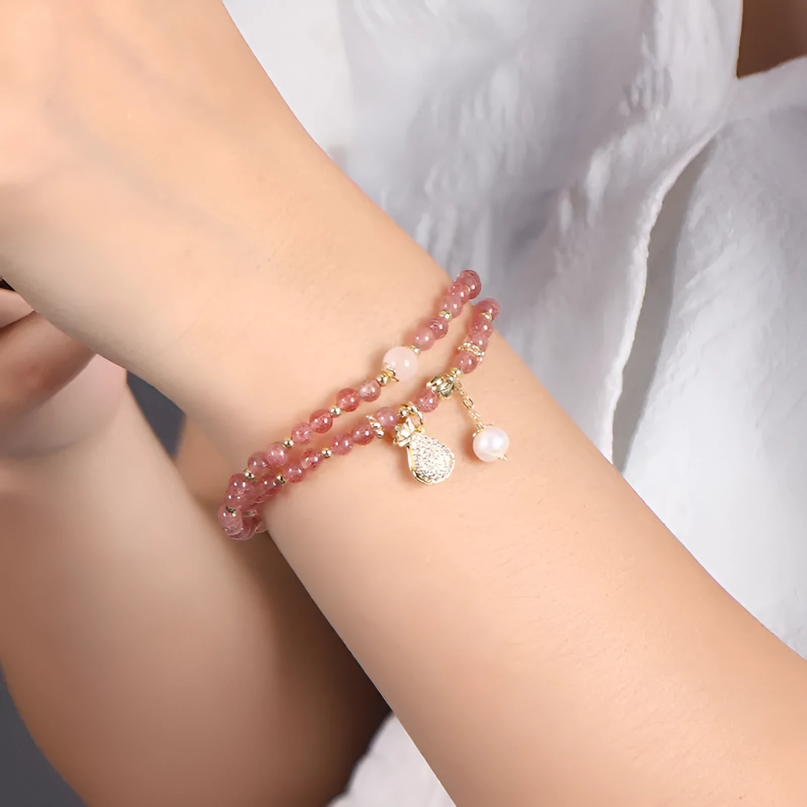 Women's strawberry quartz bracelet with geometric wallet-style design and adjustable beaded construction