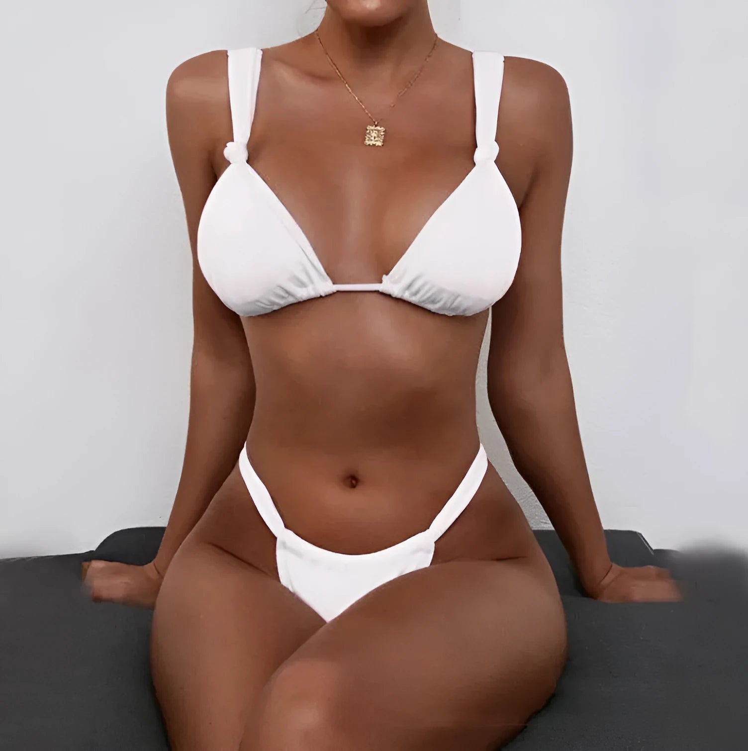 Pink women's bikini with a knotted top, split straps, and matching briefs on a neutral background.