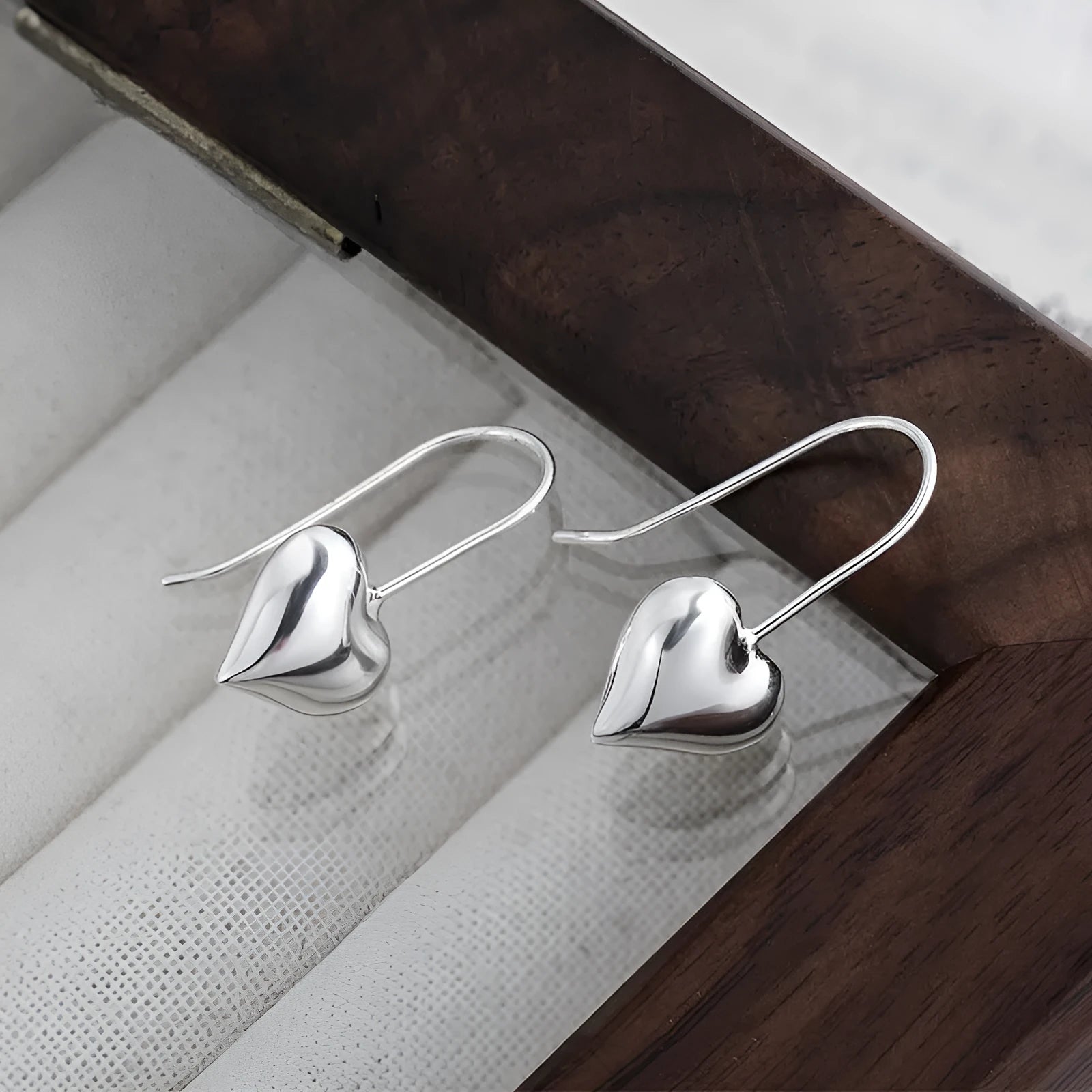 Silver colour heart-shaped earrings with glossy finish and three-dimensional Korean style design