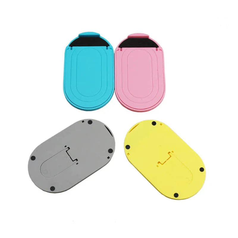 Plastic lazy bracket mobile phone stand in multiple colours on a desk