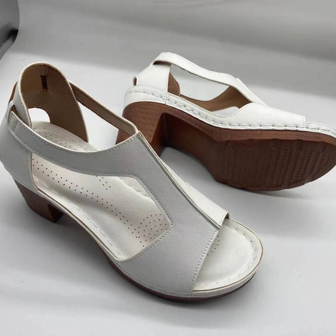 Women's beige peep toe wedge sandals with a buckle strap and low Roman-style heel.