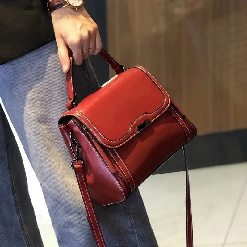 Women's brown genuine oil wax leather messenger bag showing front view with double straps and visible sewing details.