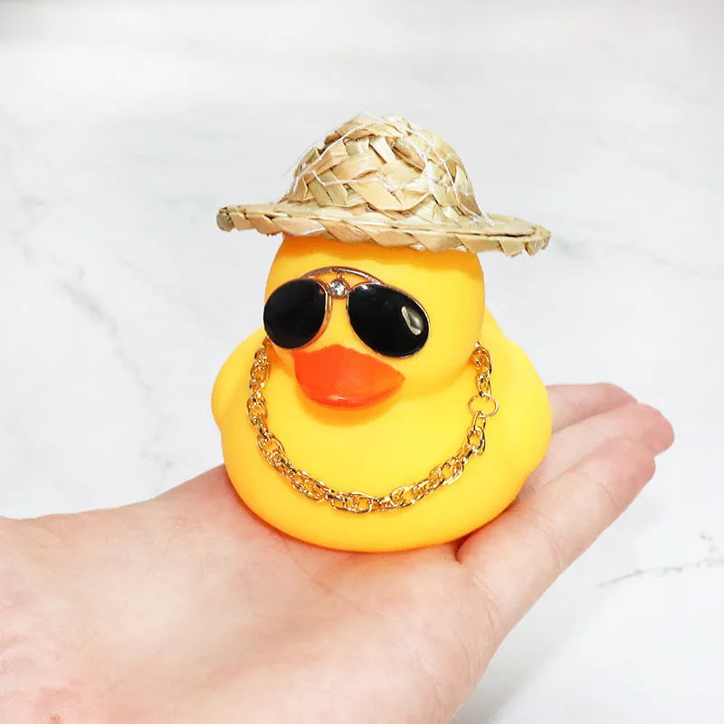 Straw hat yellow duck car dashboard ornament with removable sunglasses necklace on adhesive base.