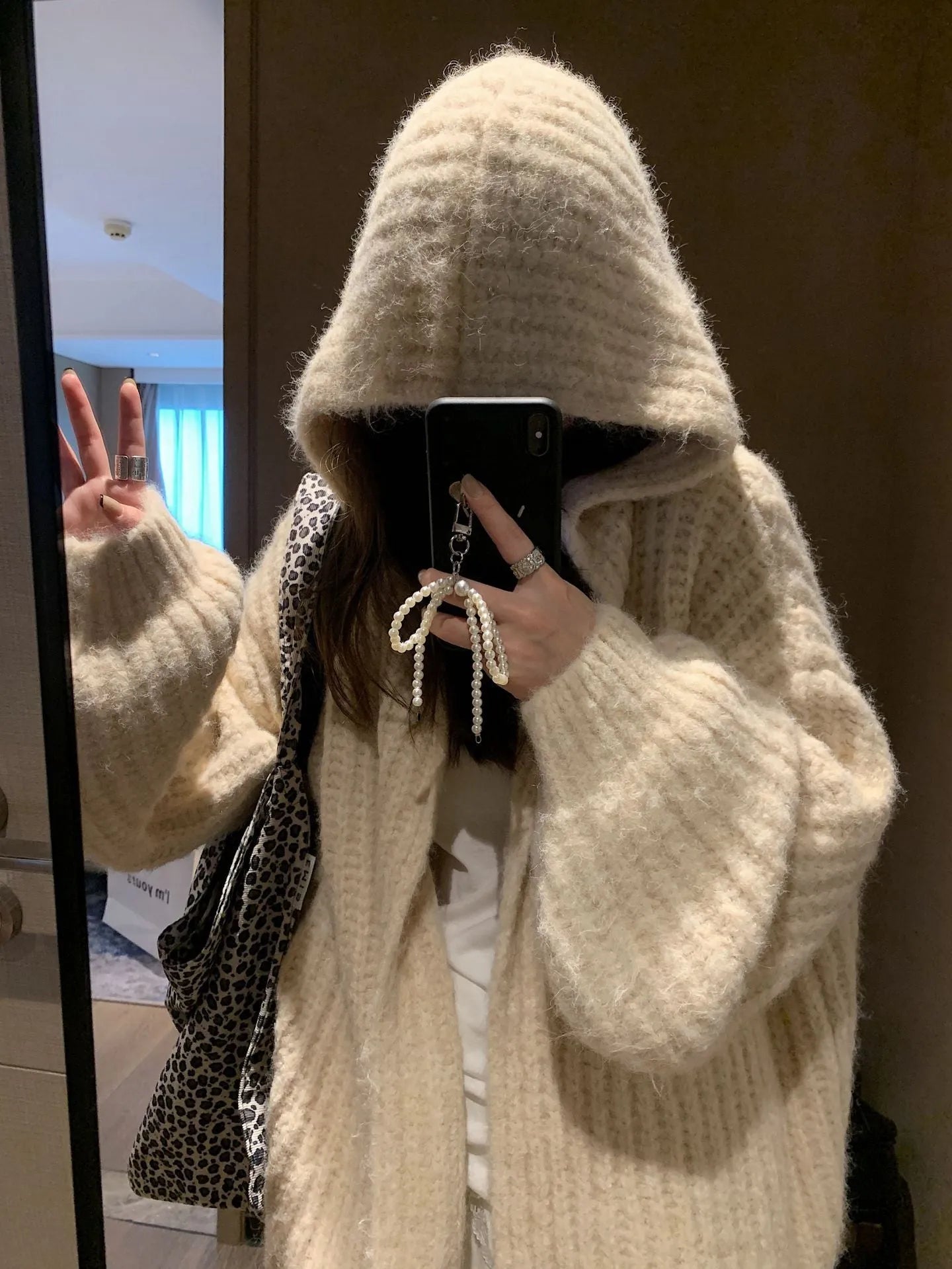 Women's loose hooded cardigan in thick acrylic blend, shown in dark grey, brown, and milky white.