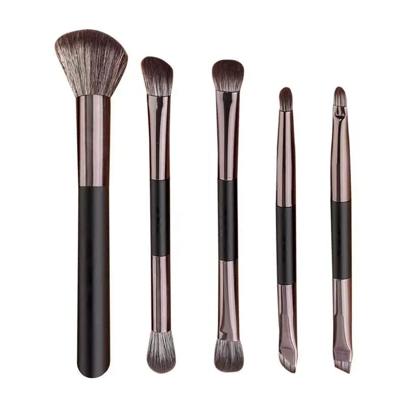 Compact makeup brush set with mirror showing silver or gold finish brushes with artificial fibre heads
