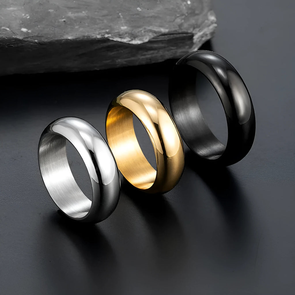 Glossy electroplated titanium steel ring in gold, black, and steel colours on a grey background.