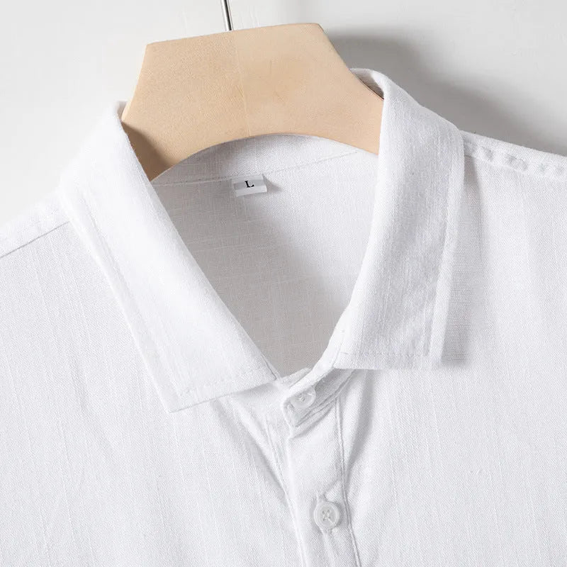 A man wearing a loose-fit linen-blend t-shirt in a solid colour with a relaxed lapel and short sleeves.