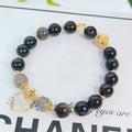 Adjustable silver stone bracelet for women with choice of flower, love, or star charm on a white background.