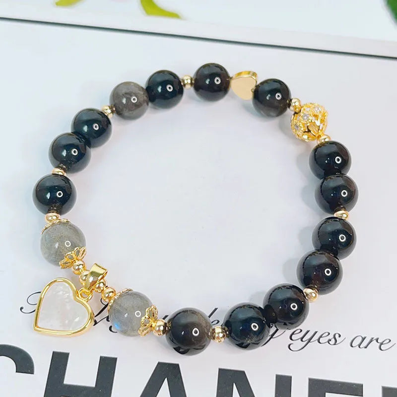 Adjustable silver stone bracelet for women with choice of flower, love, or star charm on a white background.