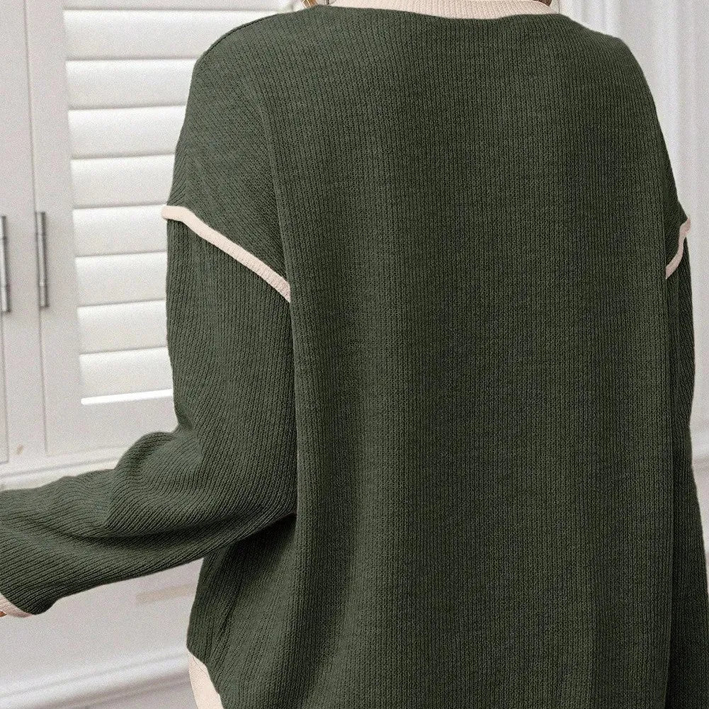 A beige loose knit top with a four leaf clover print and contrasting trim on the sleeves and hem.