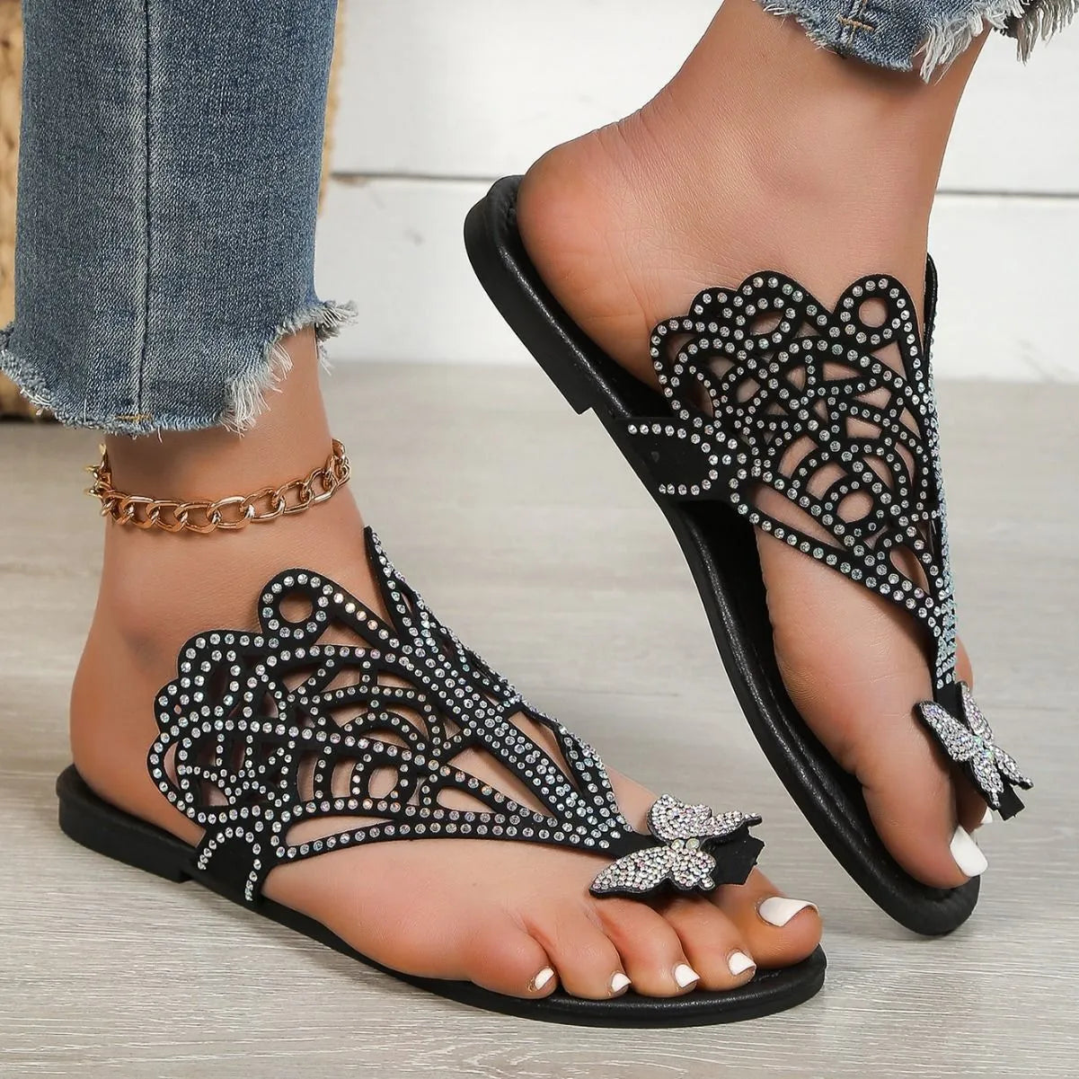 Women's black slip-on sandals with rhinestone decoration and flip-toe design.