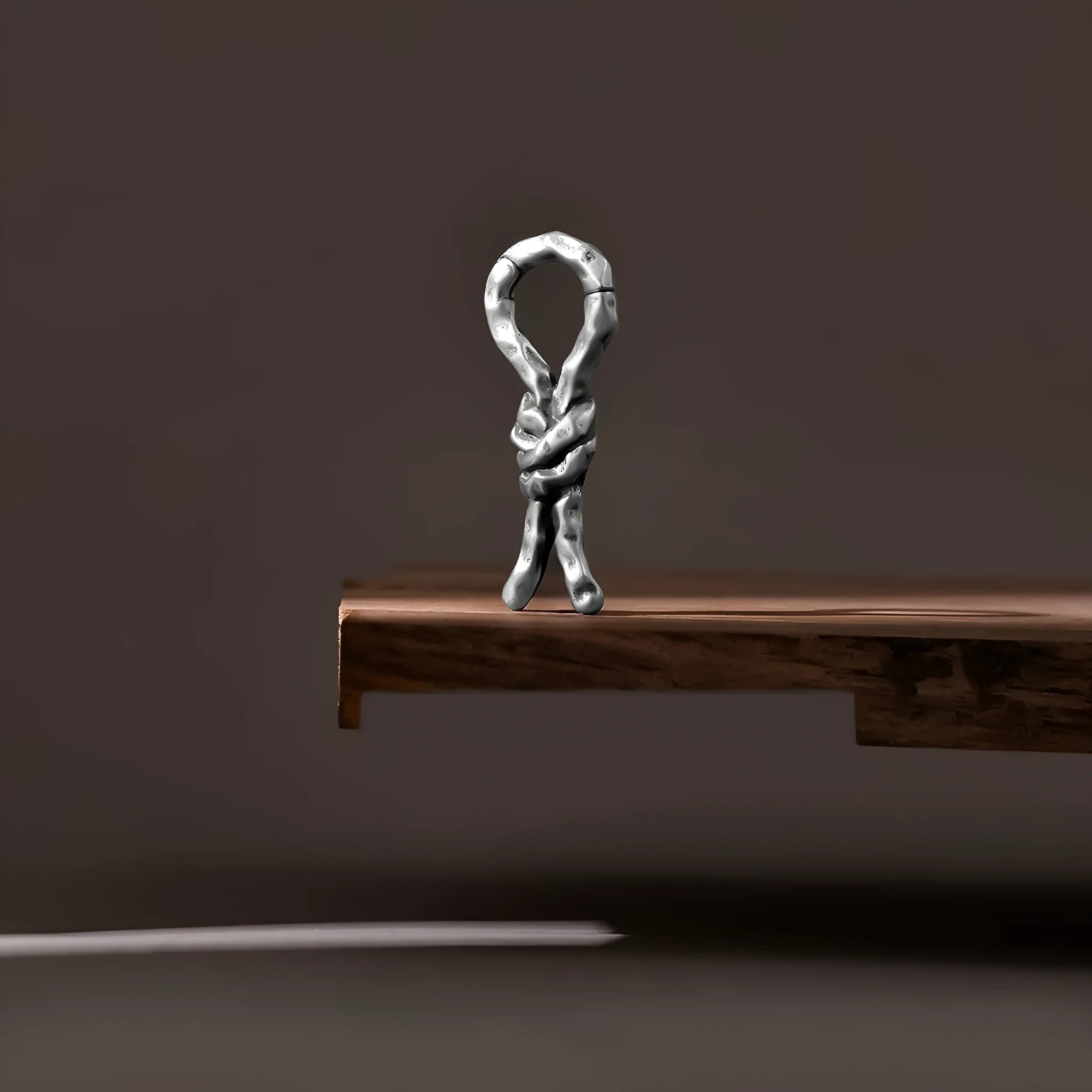 Close-up of a 4mm copper piercing earring with a bending, connecting retro shape.