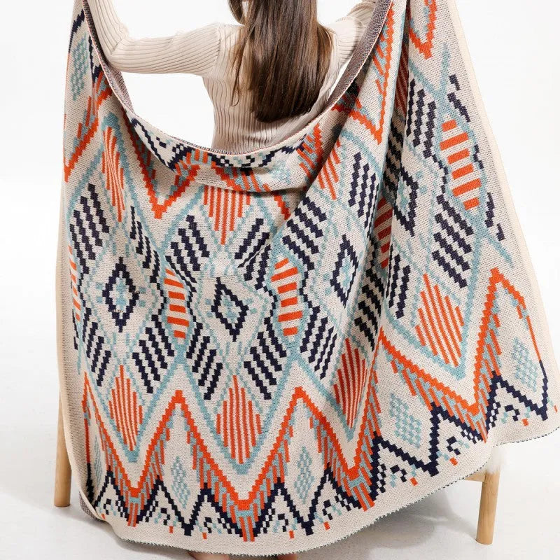 Acrylic sofa blanket with tassels in geometric pattern colour option on a sofa