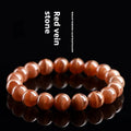 Natural rhodochrosite round bead bracelet with ruyi design on wrist.
