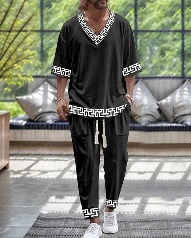 Thin polyester trousers suit with V-neck cropped sleeve jacket and matching trousers on a hanger.
