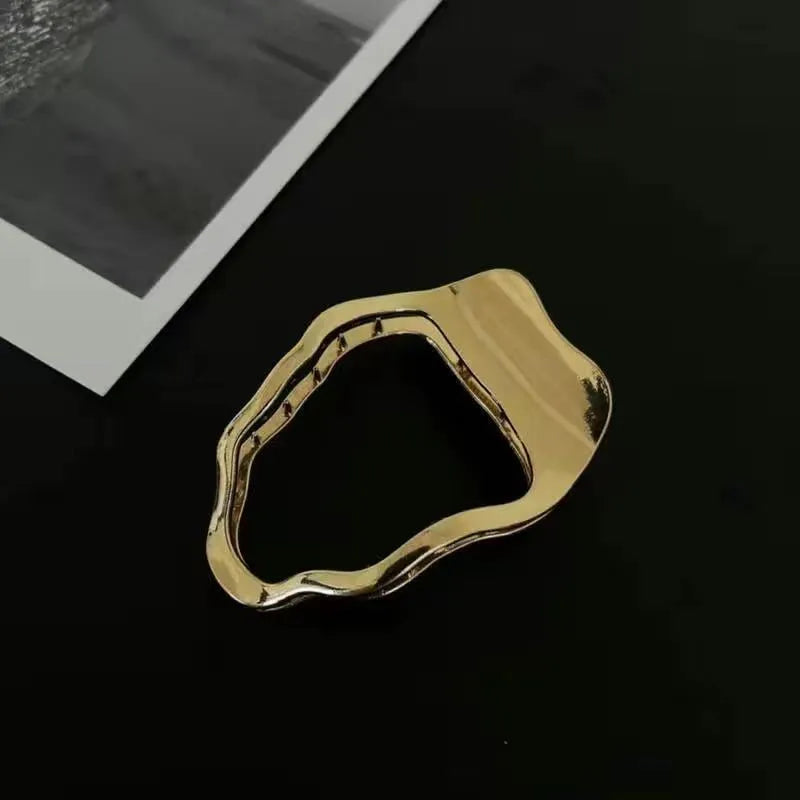 Golden zinc alloy hair barrette in an arc shape on a white background