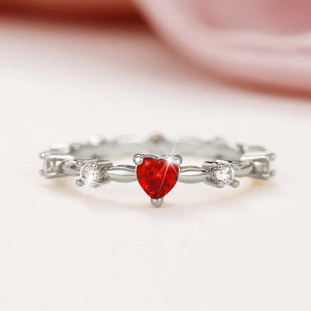 Gold tone peach heart ring with zircon stone centre on finger
