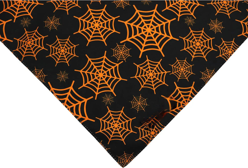 Reversible Halloween dog bandana showing pumpkin pattern on orange side and spider web design on black side