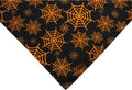 Reversible Halloween dog bandana showing pumpkin pattern on orange side and spider web design on black side