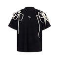 Black loose-fit T-shirt with padded shoulders featuring rivet ribbon detail, short sleeves, and round neck