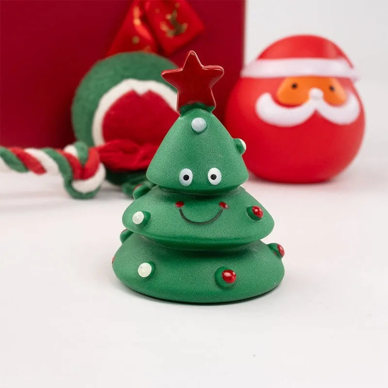 Seven Christmas gift bags containing vinyl dog toys with Santa heads, trees and deer figures