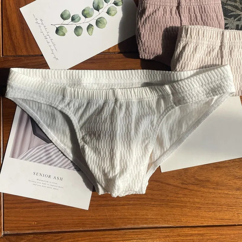 Men's solid colour cotton triangle briefs in mid-waist style, shown in apricot and black colour options.
