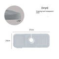 Silicone faucet pad with sloped design under a kitchen tap, showing drainage channels.