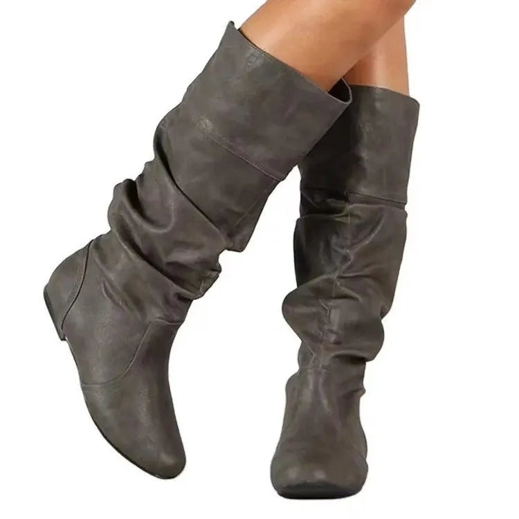 Women's black flat slip-on boots with round toe and high ankle shaft.