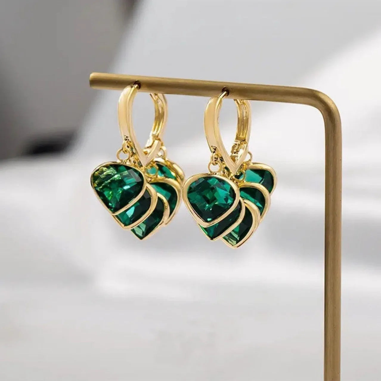 Pair of green heart-shaped pendant ear clips on a copper clip with Korean style design.