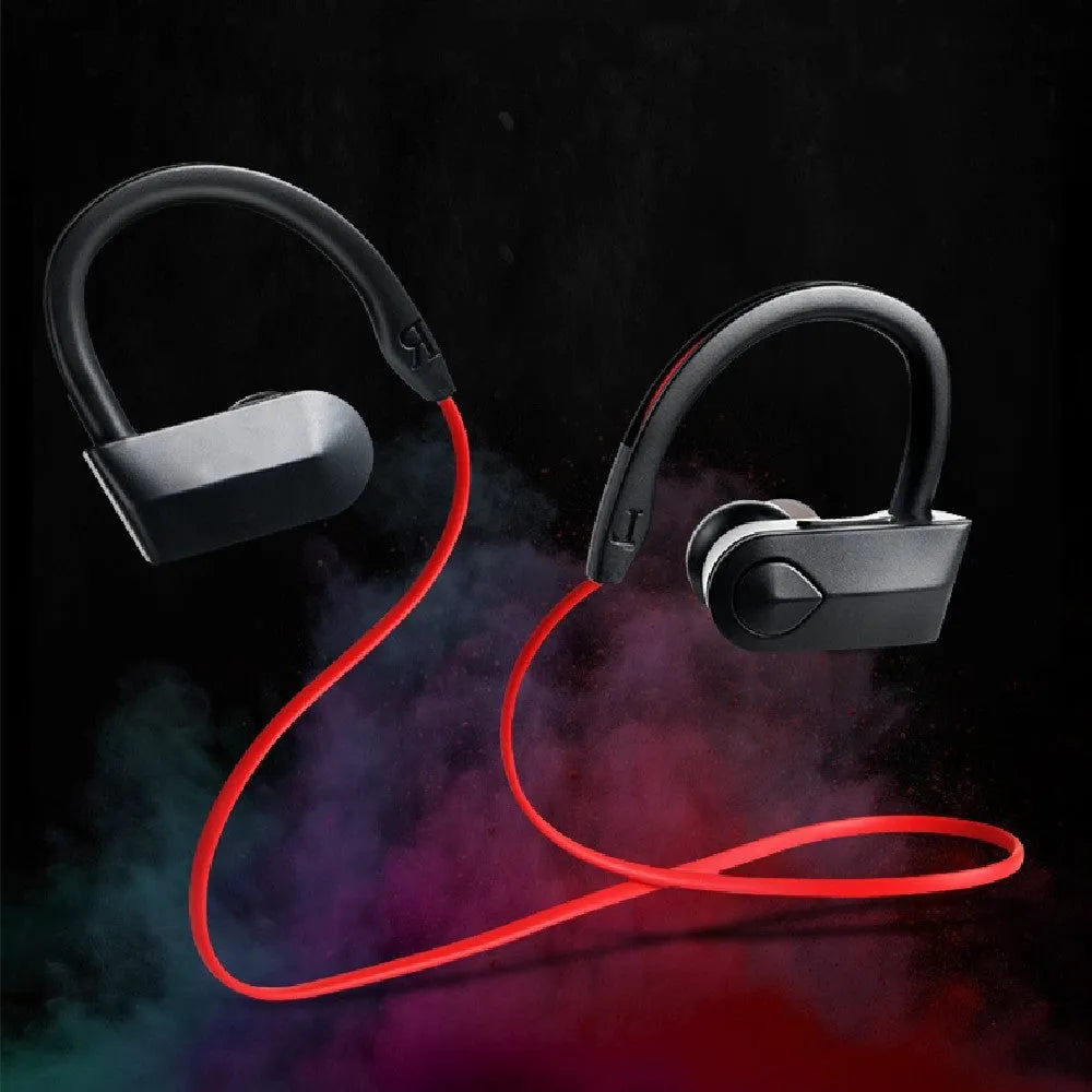 Black wireless Bluetooth neckband earphones with earpieces showing, placed next to a USB charging cable on a white background.