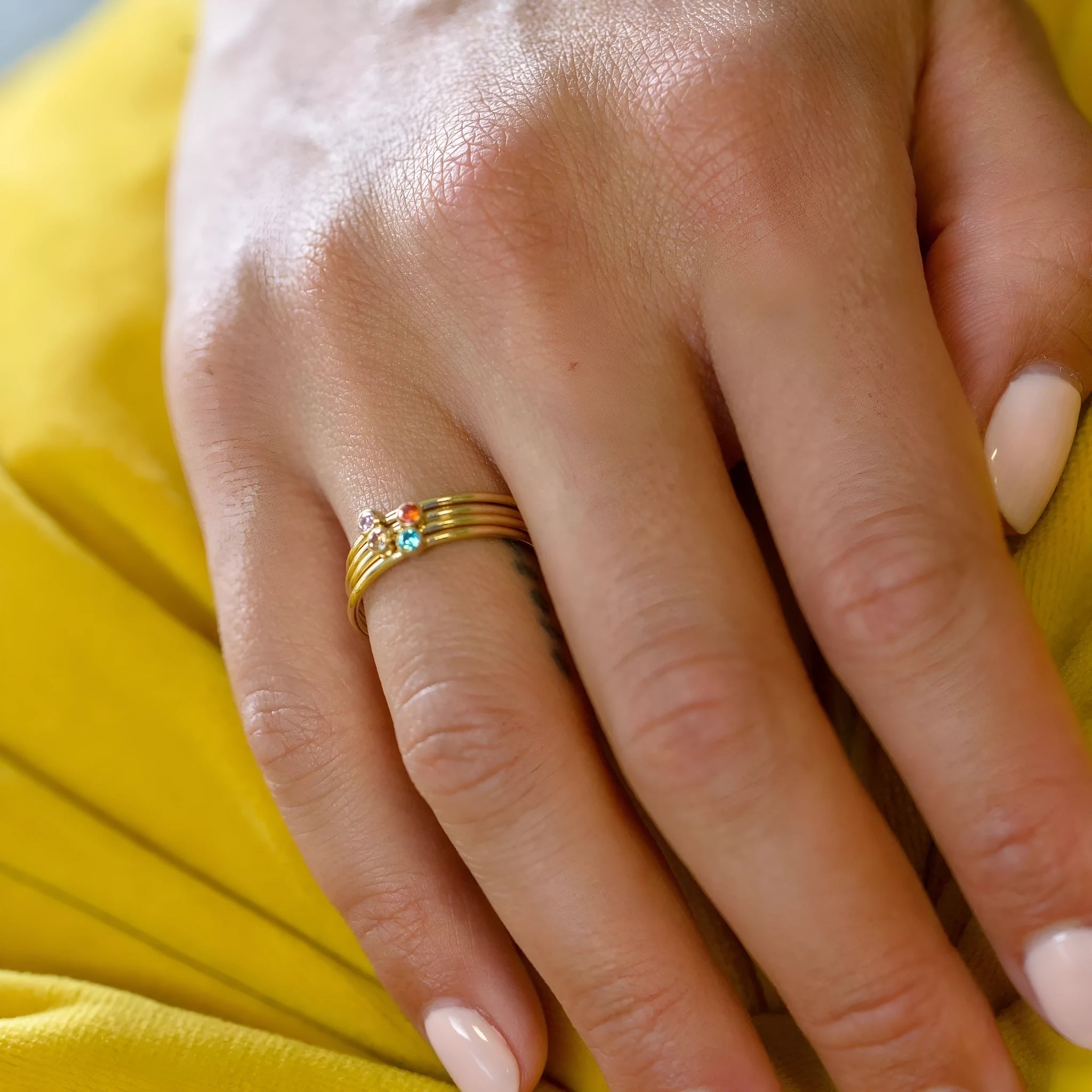 A geometric titanium steel ring featuring an engraved December birthstone design on a grey background.
