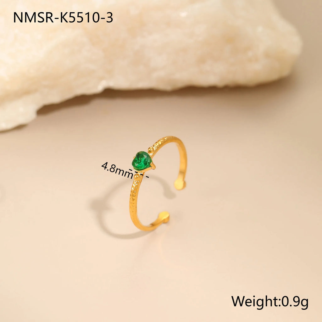 Open ended stainless steel ring with a geometric zircon-inlaid heart in white, pink, or green.