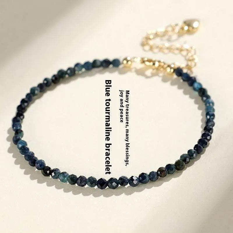 3mm blue tourmaline cut bead bracelet with spacer beads on a wrist