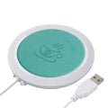 Black USB-powered high temperature heater with insulated base on a desk.