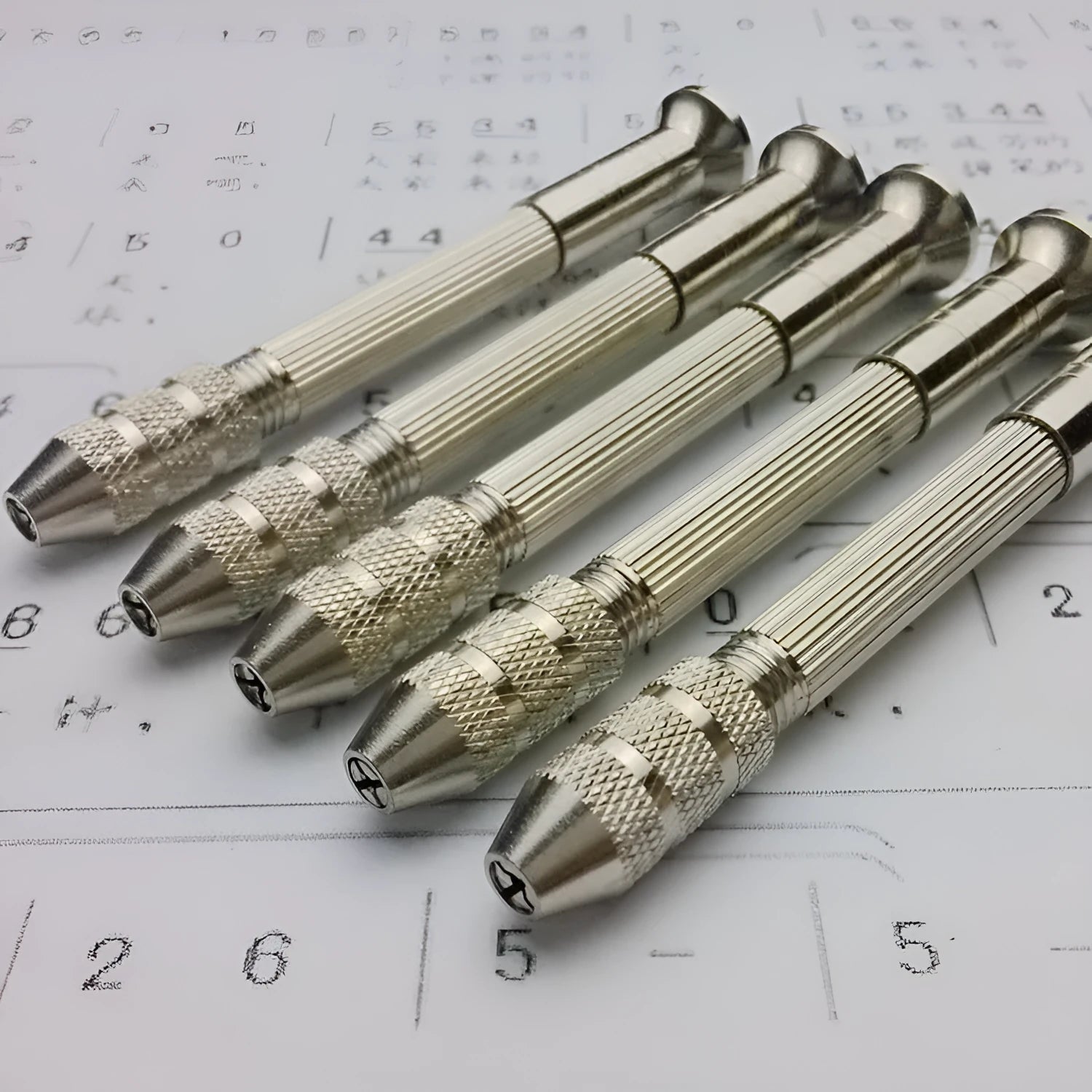 Hand twist drill with two collets and four drill bits on a wooden surface