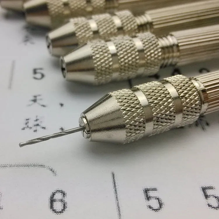 Hand twist drill with two collets and four drill bits on a wooden surface