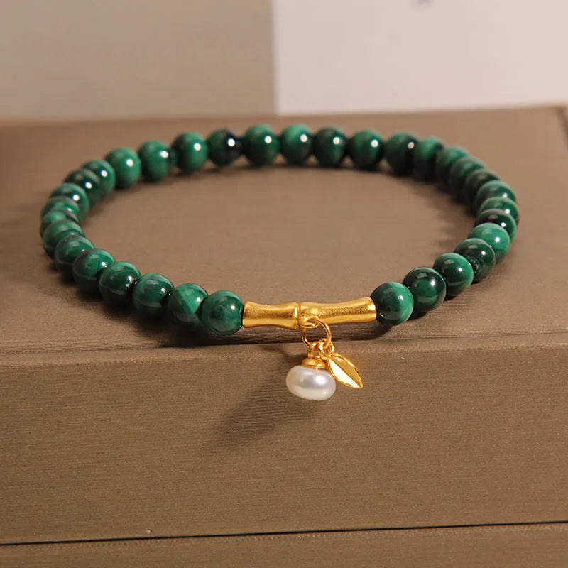 Close-up of a women's white crystal bracelet with a raised lucky bamboo design on the wrist.