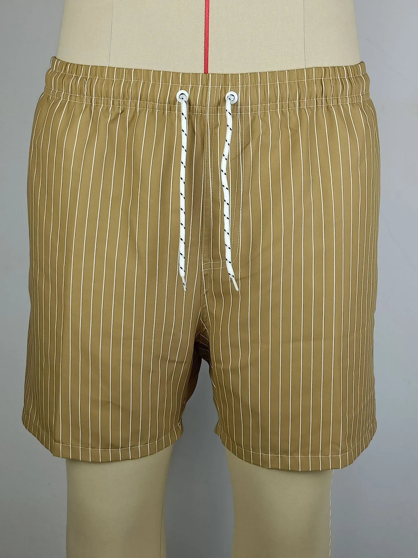 Polyester fibre beach shorts with digital printed striped triangle lining in straight leg style