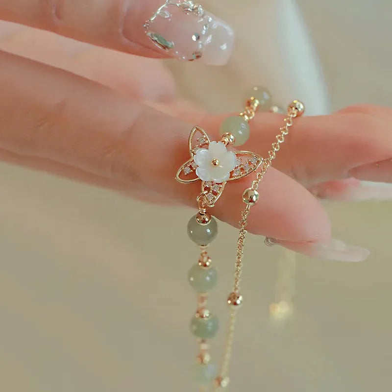 Yellow gold shell flower butterfly bracelet for women with geometric shape and bells of Ireland design
