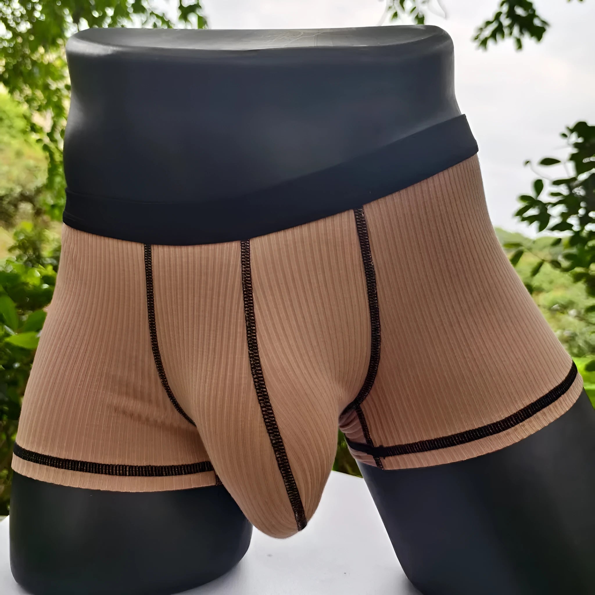 Solid colour men's boxers on a white background, showing thin breathable fabric and body-shaping fit.