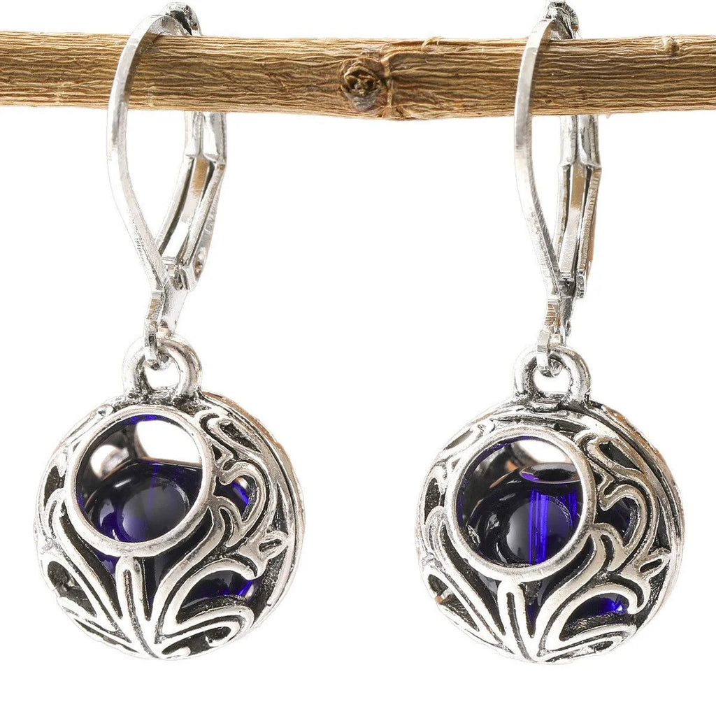 Silver tone pendant earrings with hollow geometric design, blue gemstones, and vintage engraving detail